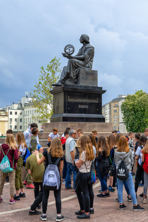 Warsaw, Poland - May 20, 2019: Group of school children on a sightseeing tour at Nicolaus Copernicus Monument, bronze statue of a Polish astronomer from 1830, city landmark.のeditorial素材