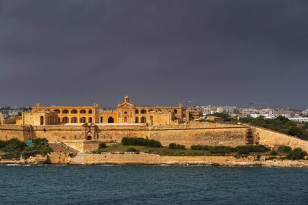 Fort Manoel on Manoel Island in Gzira, Malta, stormy sky above 18th century city landmark built by...