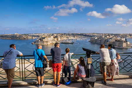 Valletta, Malta - October 13, 2019: Group of tourists enjoying the view of the Three Cities and Grand Harbour from Upper Barrakka Gardens viewpoint in capital cityのeditorial素材