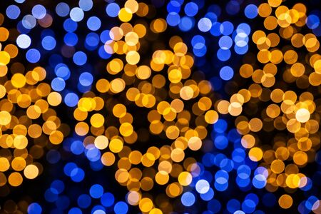 Vivid blue and orange circles, abstract festive background of blurred soft dots of holiday illumination bokehの写真素材