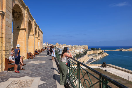 Valletta, Malta - October 11, 2019: People enjoy the view from the Upper Barrakka Gardens viewpoint terraceのeditorial素材