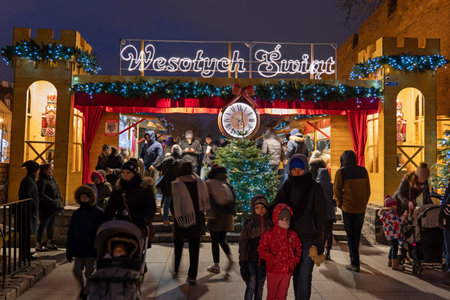 Warsaw, Poland - December 27, 2019: People entering and leaving Christmas Market at night, place to buy traditional merchandise in Old Town of capital city during holiday seasonのeditorial素材