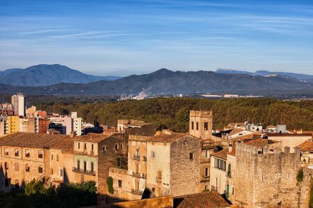 Traditional stone houses of Girona city in Spain, Catalonia region landscape with mountains on the horizon.の写真素材