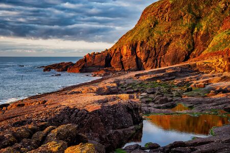 Tranquil sunrise by the sea in south coast of Ireland, Dunmore East, County Waterford.の写真素材