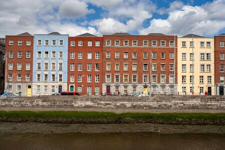 City of Dublin in Ireland, row of houses, apartment buildings along embankment of River Liffey.の写真素材