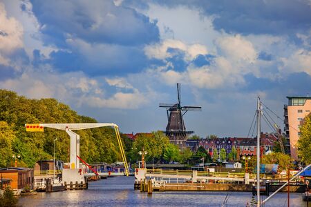 City skyline of Amsterdam in Holland, the Netherlands, Nieuwevaart canal with a drawbridge and De Gooyer Windmillの写真素材