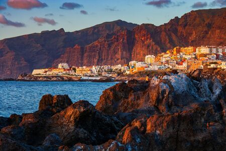 Tenerife island at sunset in Spain, view to Los Gigantes resort town and cliffs, scenic coastline of Canary Islands in the Atlantic Oceanの写真素材