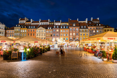 Warsaw, Poland - May 31, 2019: Houses and outdoor restaurant tables on the Old Town Market Square at night in capital city historic centreのeditorial素材