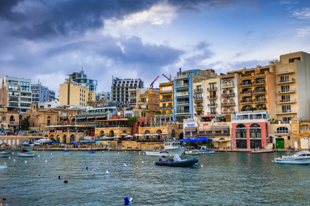Paceville, St Julian, Malta - October 10, 2019: Paceville town popular nightlife hub, buildings and boats at Spinola Bayのeditorial素材