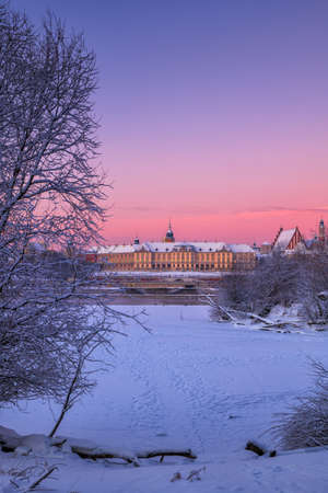 Winter dawn at Vistula river in city of Warsaw, Poland, view to the Royal Castle in the Old Town.の写真素材