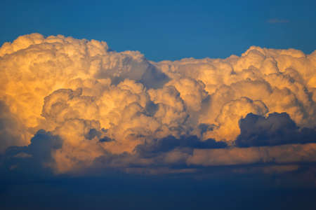 Sky with stormy cumulonimbus cloud at sunset, natural background.
