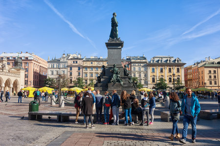 Krakow (Cracow), Poland - September 30, 2018: Group of people, school class children in front of Adam Mickiewicz Monument on Main Market Square in the Old Town, city landmark.のeditorial素材