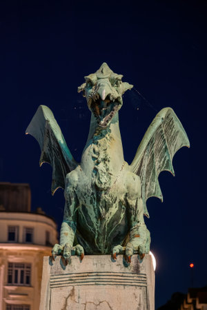 The Dragon statue at night on the Dragon Bridge in Ljubljana, Slovenia, city landmark, front view.の写真素材