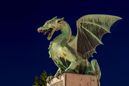 The Dragon statue at night on the Dragon Bridge in Ljubljana, Slovenia, city landmark.の写真素材
