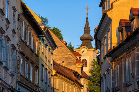 Sunset In the Old Town of Ljubljana city in Slovenia. Traditional houses along  Gornji Trg street and tower of St. Florian Church (Slovene: Cerkev svetega Florijana).の写真素材