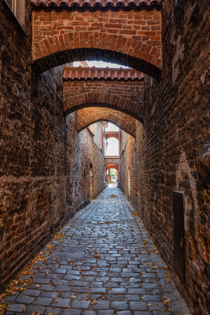 Medieval alleyway in Old Town of Elblag city in Poland. Narrow cobblestone passage between tenement houses called "The Church Path".の写真素材