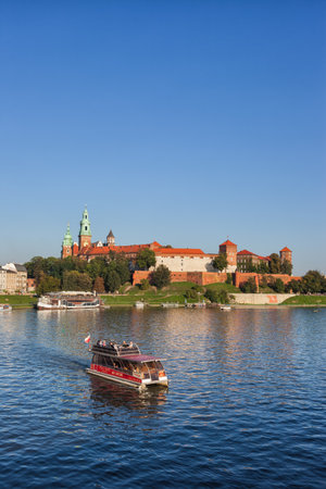 Krakow, Poland - September 19, 2018 - The Wawel Castle and tour boat on Vistula River with tourists on sightseeing tour.のeditorial素材