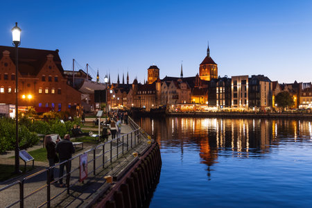Gdansk, Poland - October 9, 2022 - People on riverside promenade on Olowianka Island and city...