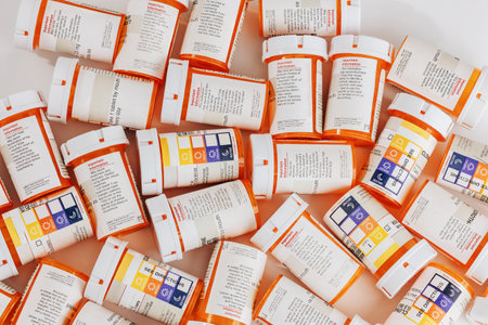 A bunch of prescription pill bottles grouped on a table with white background.の写真素材