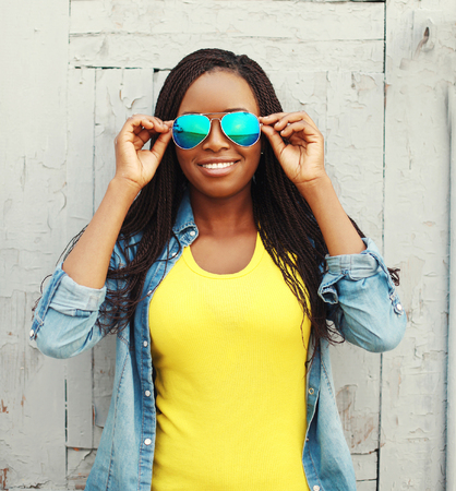 Portrait happy smiling african woman in colorful clothes and sunglassesの写真素材