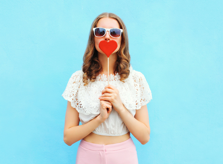 Pretty woman and lollipop over colorful blue backgroundの写真素材