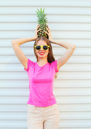 Fashion pretty woman in sunglasses with pineapple over white backgroundの写真素材