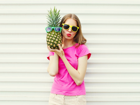 Fashion pretty cool girl in sunglasses with pineapple over white backgroundの写真素材