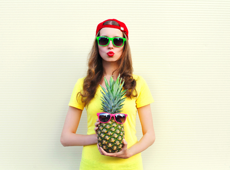 Fashion pretty cool girl with pineapple over white backgroundの写真素材