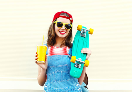 Happy pretty cool smiling woman with cup and skateboard over white backgroundの写真素材