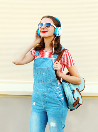 Portrait happy woman listens to music in headphones over white backgroundの写真素材