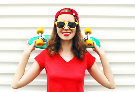 Fashion pretty cool smiling woman with skateboard over white backgroundの写真素材