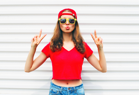 Fashion pretty cool woman in sunglasses and red t-shirt over white backgroundの写真素材
