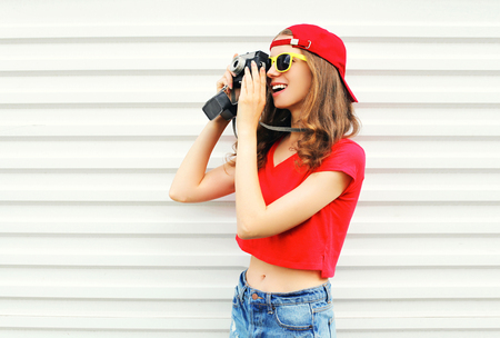 Fashion pretty cool woman with retro camera over white background profile viewの写真素材