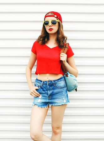 Fashion pretty woman in sunglasses and shorts over white backgroundの写真素材