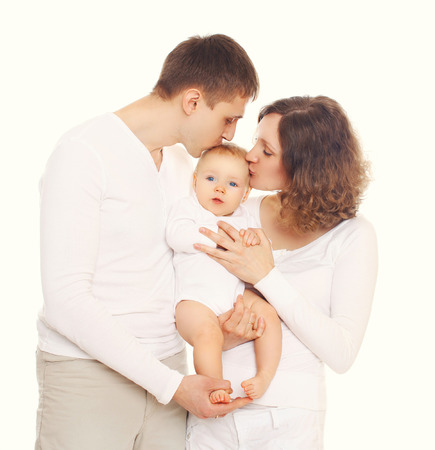 Happy family mother and father kissing baby on white backgroundの写真素材