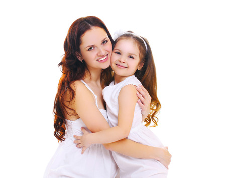 Happy smiling mother hugging little child daughter on a white backgroundの写真素材