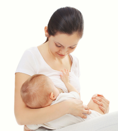 Happy mother feeding breast her baby over white backgroundの写真素材