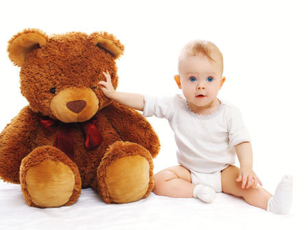 Cute baby sitting with big teddy bear on white backgroundの写真素材