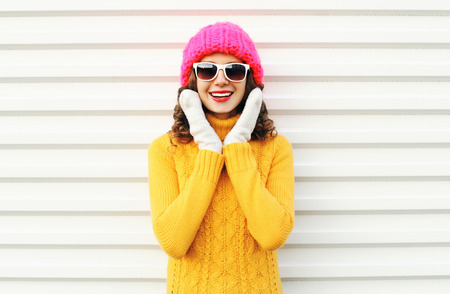 happy smiling woman having fun wearing colorful knitted pink hat over white background