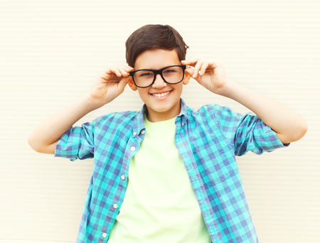 Portrait happy smiling teenager boy in glasses wearing a checkered shirt on white backgroundの写真素材