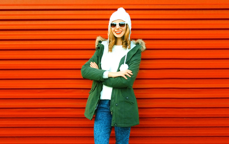 Fashion happy smiling woman posing on red background in cityの写真素材