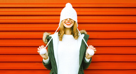 Portrait happy smiling woman in knitted hat and sweater having fun on colorful red backgroundの写真素材