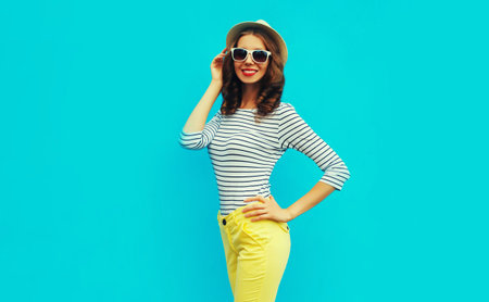 Portrait of happy smiling stylish young woman posing wearing a striped t-shirt and summer straw...