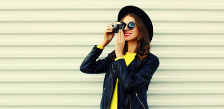 Portrait of happy smiling young woman photographer with film camera on white backgroundの写真素材