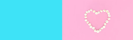 Heart shaped flower petals on colorful pink background, top view, flat lay, blank copy space fore advertising textの写真素材
