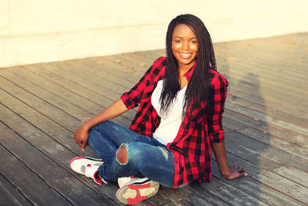 Portrait of happy smiling young african woman in casual in the cityの写真素材