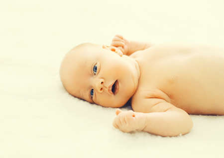 Close up portrait of infant sweet sleeping on white bed at home