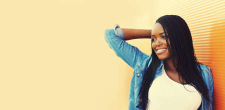 Portrait of happy smiling young african woman in casual in the cityの写真素材