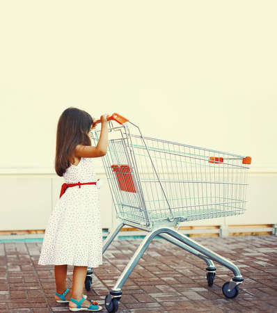 Happy smiling child with trolley cart in the cityの写真素材