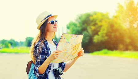 Portrait of young woman tourist sightseeing city with paper map